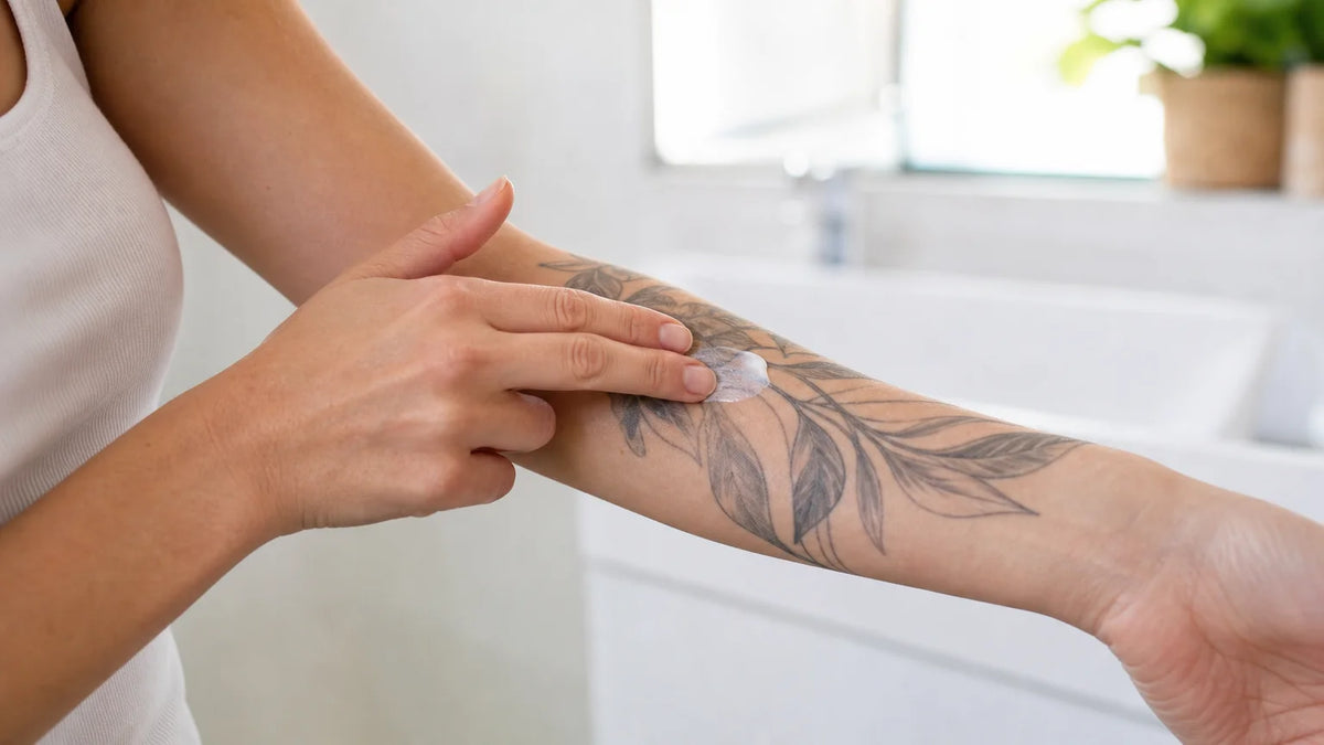Une personne applique doucement un soin sur un tatouage cicatrisé