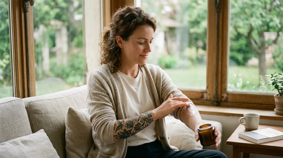 Personne appliquant une crème d'entretien sur son avant-bras tatoué Image