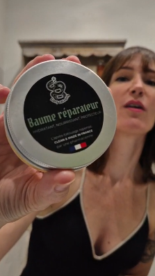 Femme de 45ans qui applique le baume sur bras tatoué